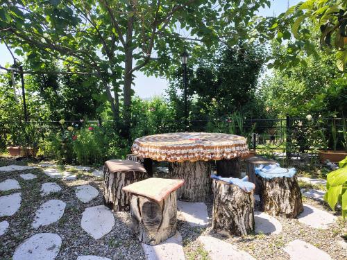 a table and four stools sitting on tree stump logs at NarInn Guesthouse in İsmayıllı