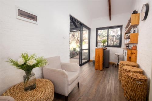a living room with a couch and a table with a vase at Miombo Mountain Lodge and Spa in Pearson Settlement