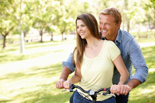 a man and woman riding a bike in a park at salinenparc Design Budget Hotel in Erwitte