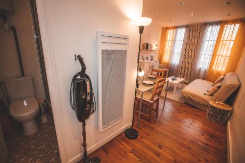 une pièce avec une pièce avec des toilettes et une table dans l'établissement Cocooning studio Rue Raphaël, au Puy-en-Velay
