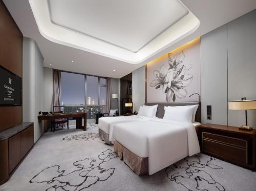 a bedroom with a large white bed and a desk at Kempinski Hotel Changsha in Changsha