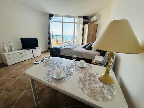 a living room with a table with glasses and a lamp at PSB Apartments in Midia Resort Aheloy in Aheloy