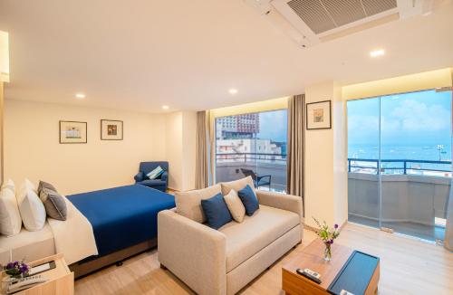 a bedroom with a bed and a couch at Sunbeam Hotel Pattaya in Pattaya