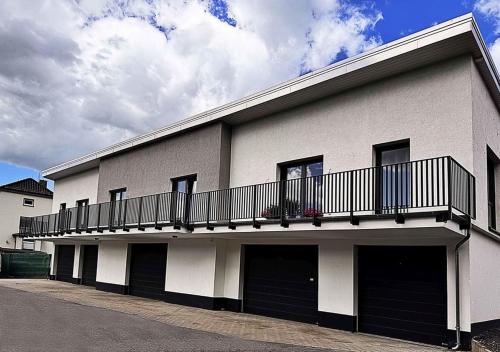 a white building with a balcony on top of it at Neues Ruhrtal Apartment 5 mit Klimaanlage in Wickede (Ruhr)