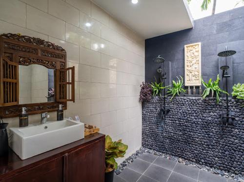 a bathroom with a sink and a mirror at The Manja Retreat Lovina in Buleleng