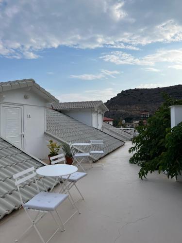 a patio with chairs and a table on a roof at Paradisos in Áyioi Pándes