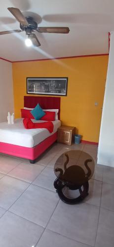 a bedroom with a bed and a table in a room at Neo & Ruks Guest Houses parow 4 in Avondale