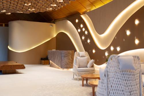 a lobby with two chairs and a table and a slide at Mahutsachan Khlong Thom in Krabi town