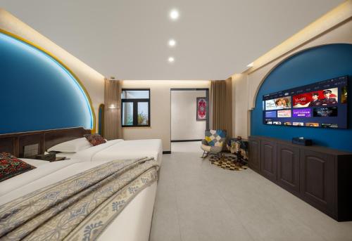 a hotel room with two beds and a flat screen tv at 浮生居设计师民宿 in Yining Airport