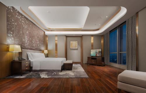 a hotel room with a bed and a tv at Kempinski Hotel Changsha in Changsha