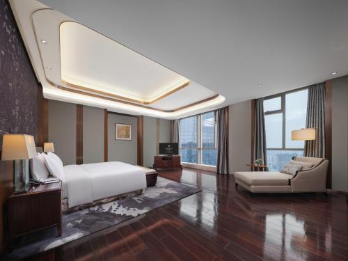 a bedroom with a white bed and a couch at Kempinski Hotel Changsha in Changsha
