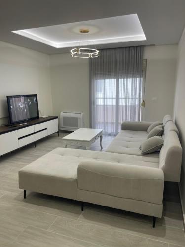 a living room with a couch and a flat screen tv at Alessio Beach House in Durrës