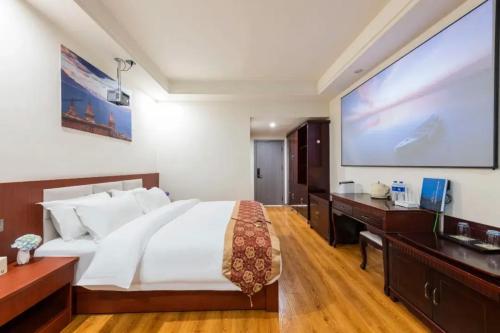 a bedroom with a large bed and a large screen at Feng Hui Snow Mountain Resort Hotel Deqin Feilai Temple Branch in Shengping
