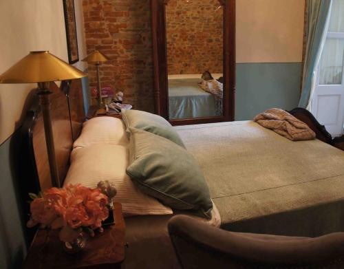 a bedroom with two beds and a mirror at Casa Dellatorre in Alba