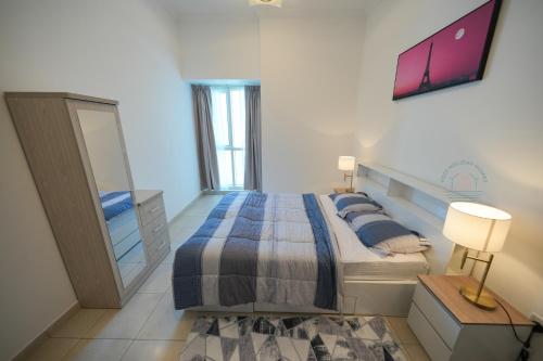 a bedroom with a large bed and a mirror at Yogi - 2BR Churchill - Floor 52 & Burj View in Dubai