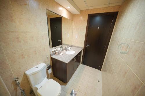 a bathroom with a toilet and a sink and a mirror at Yogi - 2BR Churchill - Floor 52 & Burj View in Dubai