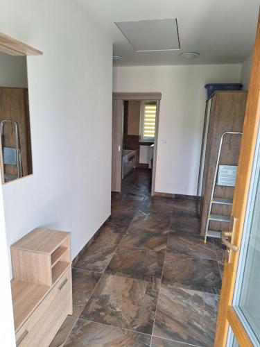 a room with a hallway with wooden floors and a staircase at Apartmán v Plané in Tachov