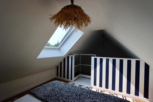 a attic room with a crib and a window at Les Suites in Camiers