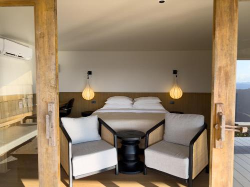 una camera da letto con un letto, un tavolo e delle sedie di Tramont a Ban Huai Khai