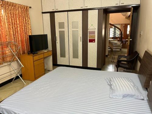 a bedroom with a large bed and a television at Eden luxury stay Coimbatore in Coimbatore