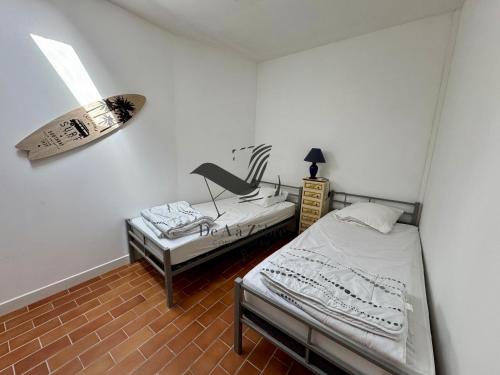 a room with two beds and a chair in it at L'Océane - Maison au calme avec terrasse, centre de Bourg in Le Port-des-Barques