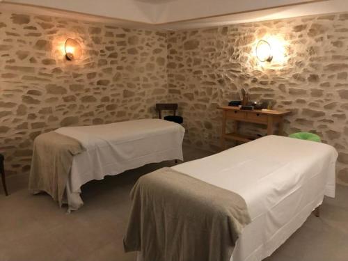 two beds in a room with stone walls at Le Relais du Bellay in Montreuil-Bellay
