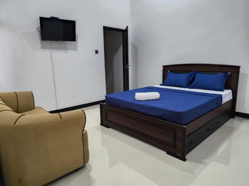 a bedroom with a bed and a couch and a chair at The Residence by Amaya in Anuradhapura