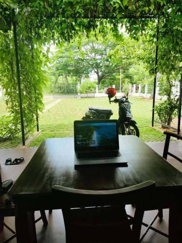 a laptop computer sitting on a table with a motorcycle in a park at The Residence by Amaya in Anuradhapura