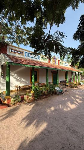 a building with green and white paint on it at Marutham Village Resort in Mahabalipuram