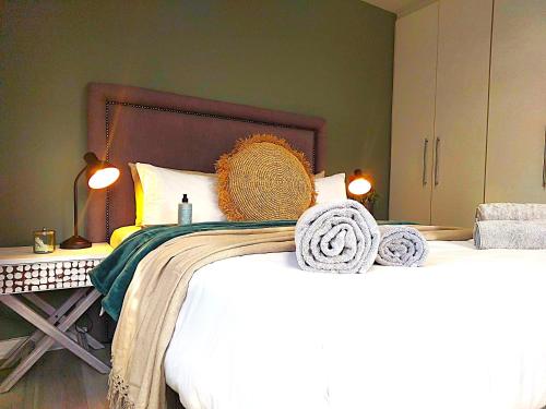 a bedroom with a large bed with towels on it at Brizzy's Garden Luxe Retreat Great Location! in Gqeberha