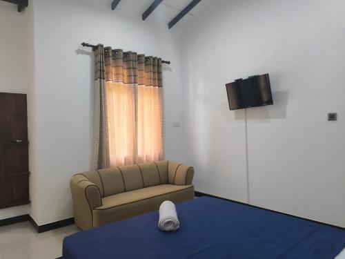 a living room with a couch and a tv at The Residence by Amaya in Anuradhapura