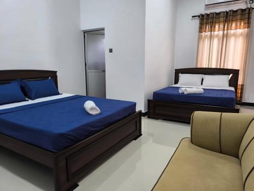 a bedroom with two beds and a couch at The Residence by Amaya in Anuradhapura