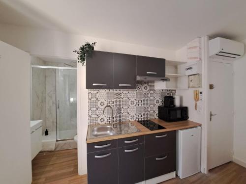 une cuisine avec un évier et un plan de travail dans l'établissement Palerme - City Appart, à Reims