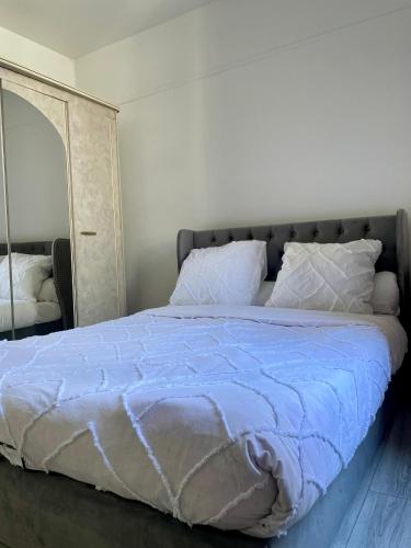 - un grand lit avec une couette bleue et un miroir dans l'établissement Logement 2 pièces très bien situé, proche parc des princes, à Boulogne-Billancourt