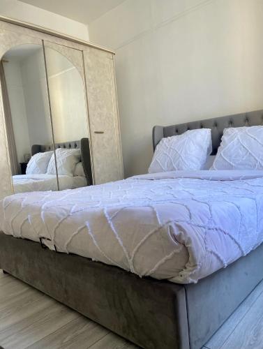 une chambre avec un grand lit avec un grand miroir dans l'établissement Logement 2 pièces très bien situé, proche parc des princes, à Boulogne-Billancourt