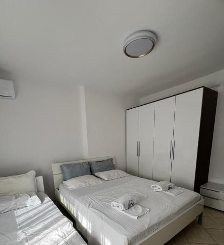a bedroom with two beds and a white cabinet at Grediv Apartment Orikum in Orikum