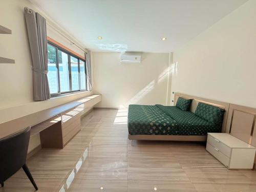 a room with a bed and a window and a couch at Quiet Harbor in Ban Saiyuan (1)