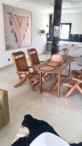a black dog laying in front of a table and chairs at Belle maison familiale spacieuse à Dakar Sénégal HOME TERANGA in Dakar