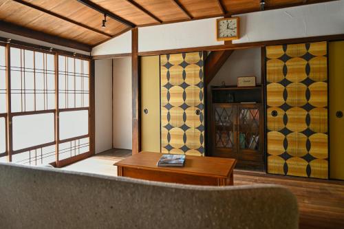 a room with a couch and a table and windows at 宿Joan in Sakurai