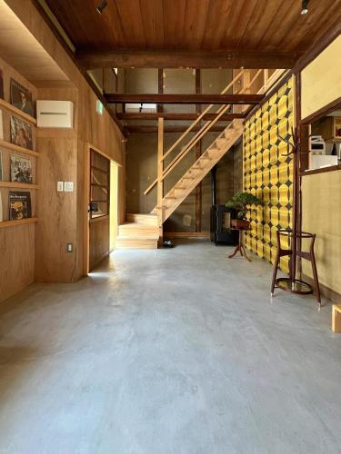 an empty room with a staircase in a building at 宿Joan in Sakurai