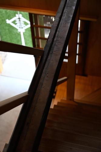 a wooden stair railing with a view of a window at 宿Joan in Sakurai