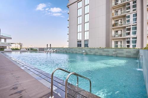 a swimming pool in front of a building at STAY BY LATINEM Luxury 1BR Holiday Home CVG 1803 near Burj Khalifa in Dubai