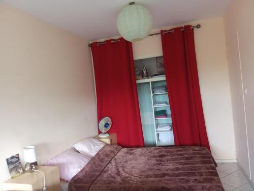 - une chambre avec des rideaux rouges et un lit dans l'établissement Studio calme et confortable, à Royat