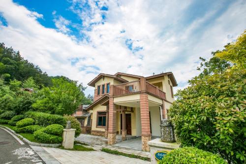 a house with a balcony on top of it at Avatar Valley Villas in Zhangjiajie