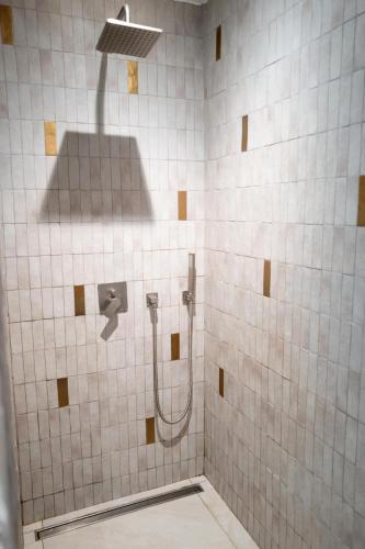 une douche carrelée blanche avec une pomme de douche et une douche dans l'établissement Joli Villa à 10 min de la plage, à Grimaud