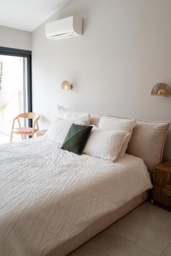 un lit blanc avec des draps et des oreillers blancs dans l'établissement Joli Villa à 10 min de la plage, à Grimaud