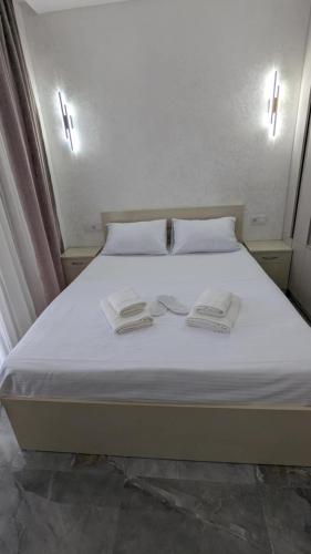 a white bed with two towels on top of it at Gizo apartments in Batumi