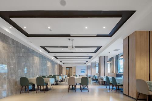 a long dining room with tables and chairs at 青年阳光酒店有限公司 in Xiamen