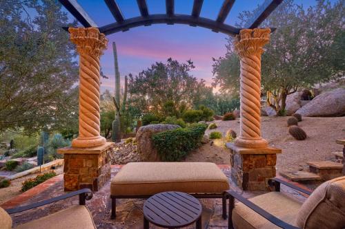 a garden with two columns and a bench and a table at Castle On Black Mountain breathtaking panoramic views and outdoor entertainment in Cave Creek