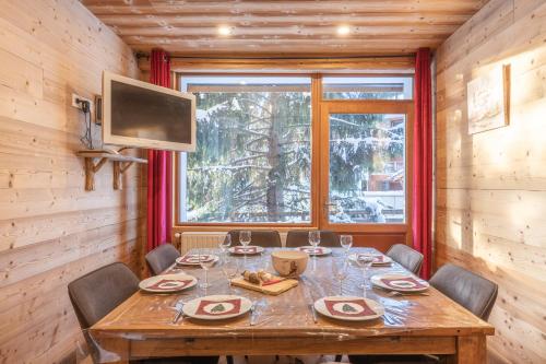 une salle à manger avec une table avec des chaises et une télévision dans l'établissement Alpe One 1850 M - 8P-50 m d'une piste et centre - Sea and Mountain Pleasure, à L'Alpe-d'Huez